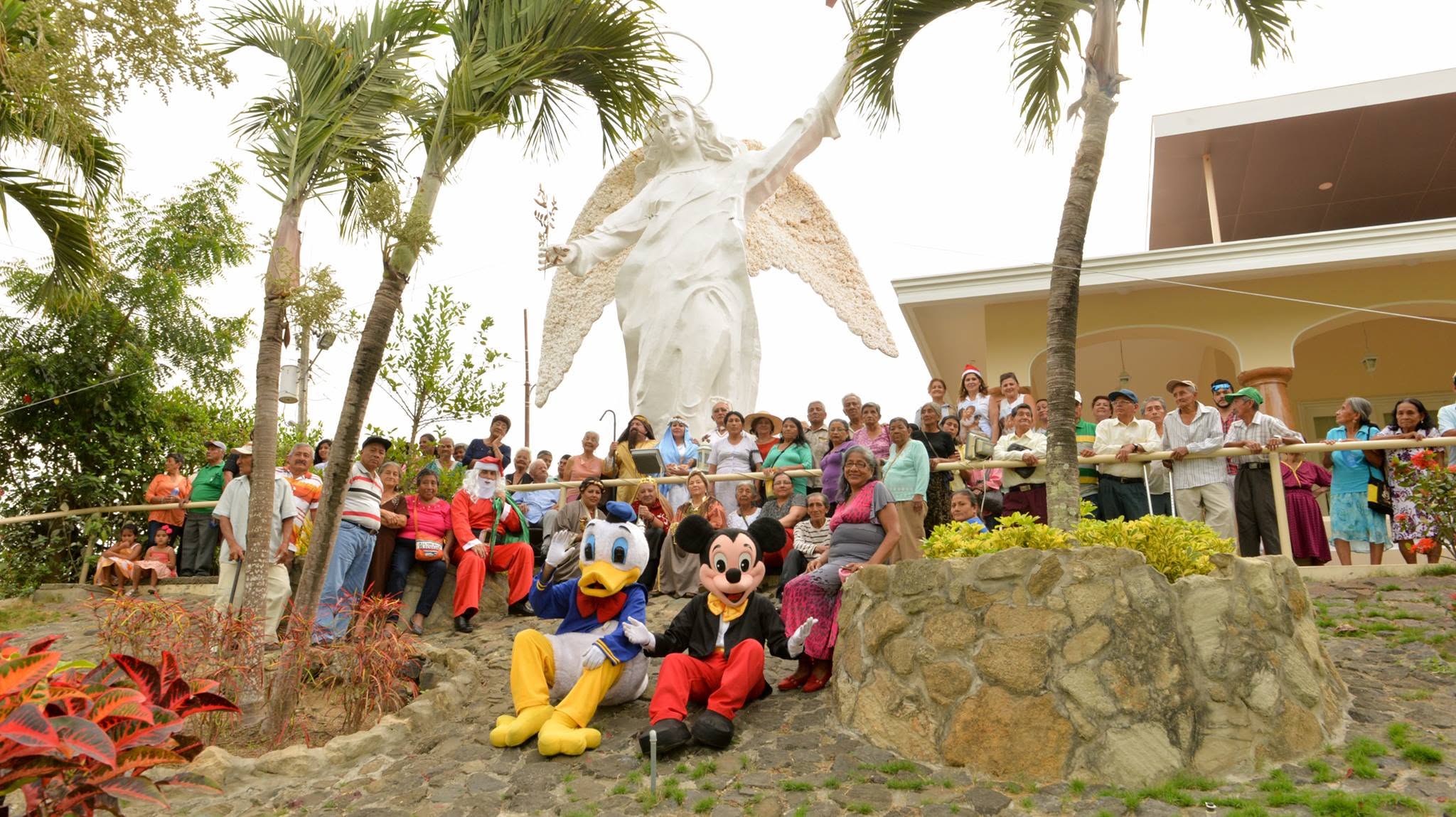 Adultos mayores y voluntarios de FUNADELÁN reunidos junto a la estatua del Ángel en una celebración de la fundación